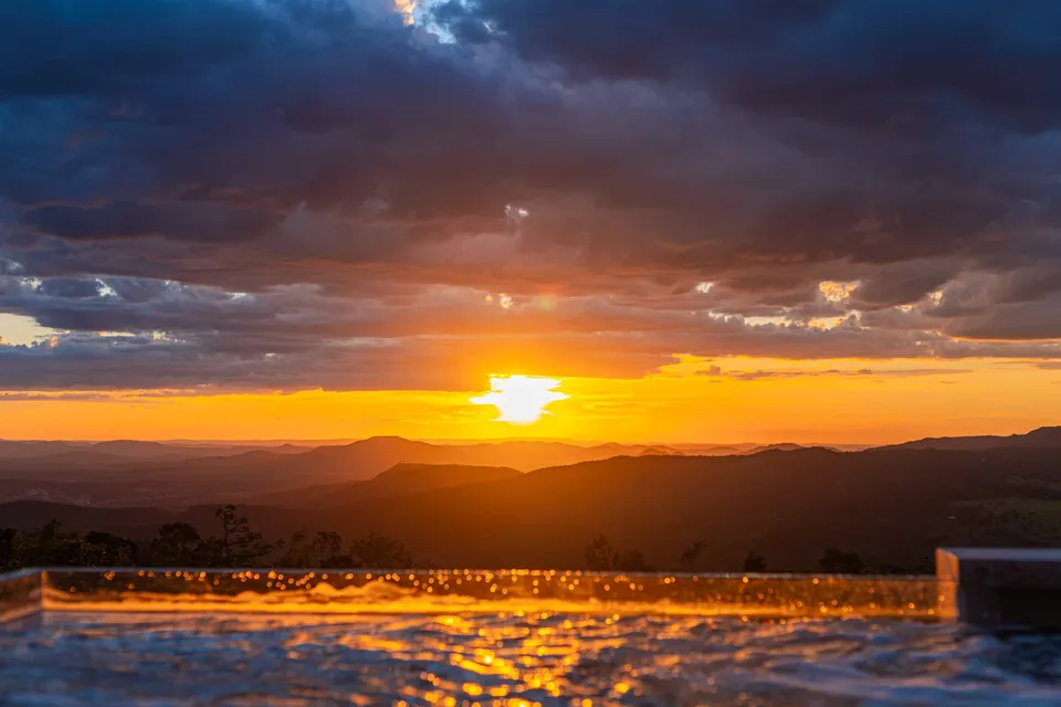 Pôr do sol sobre a Serra dos Pireneus refletido na borda da piscina